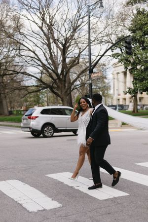 Newlyweds crossing the street in downtown Raleigh after their elopement.