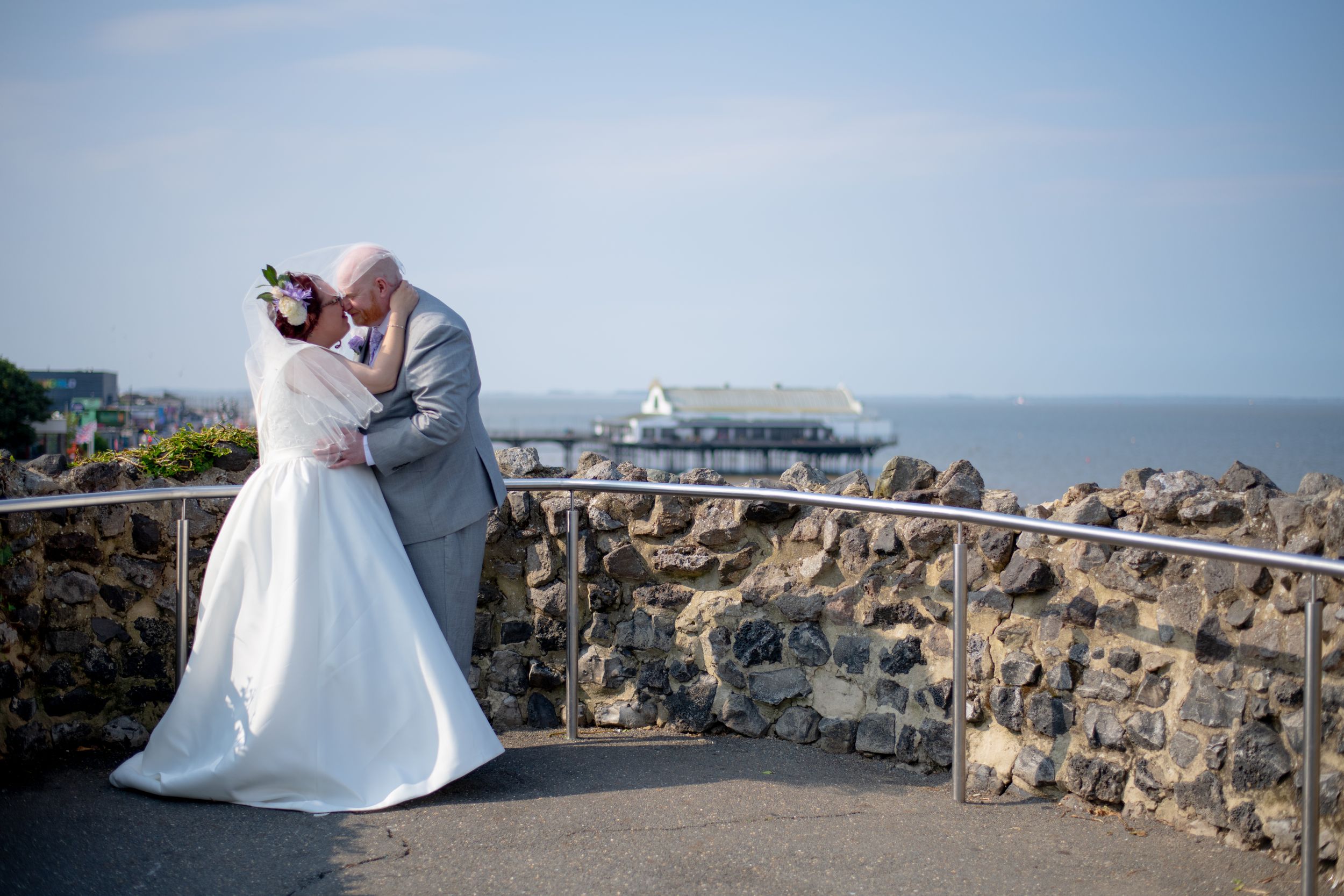 Romantic dance pose on stone terrace with cruise ship visible in background.