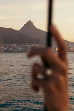 View of Lion's Head mountain through sailing equipment at sunset over Cape Town bay.