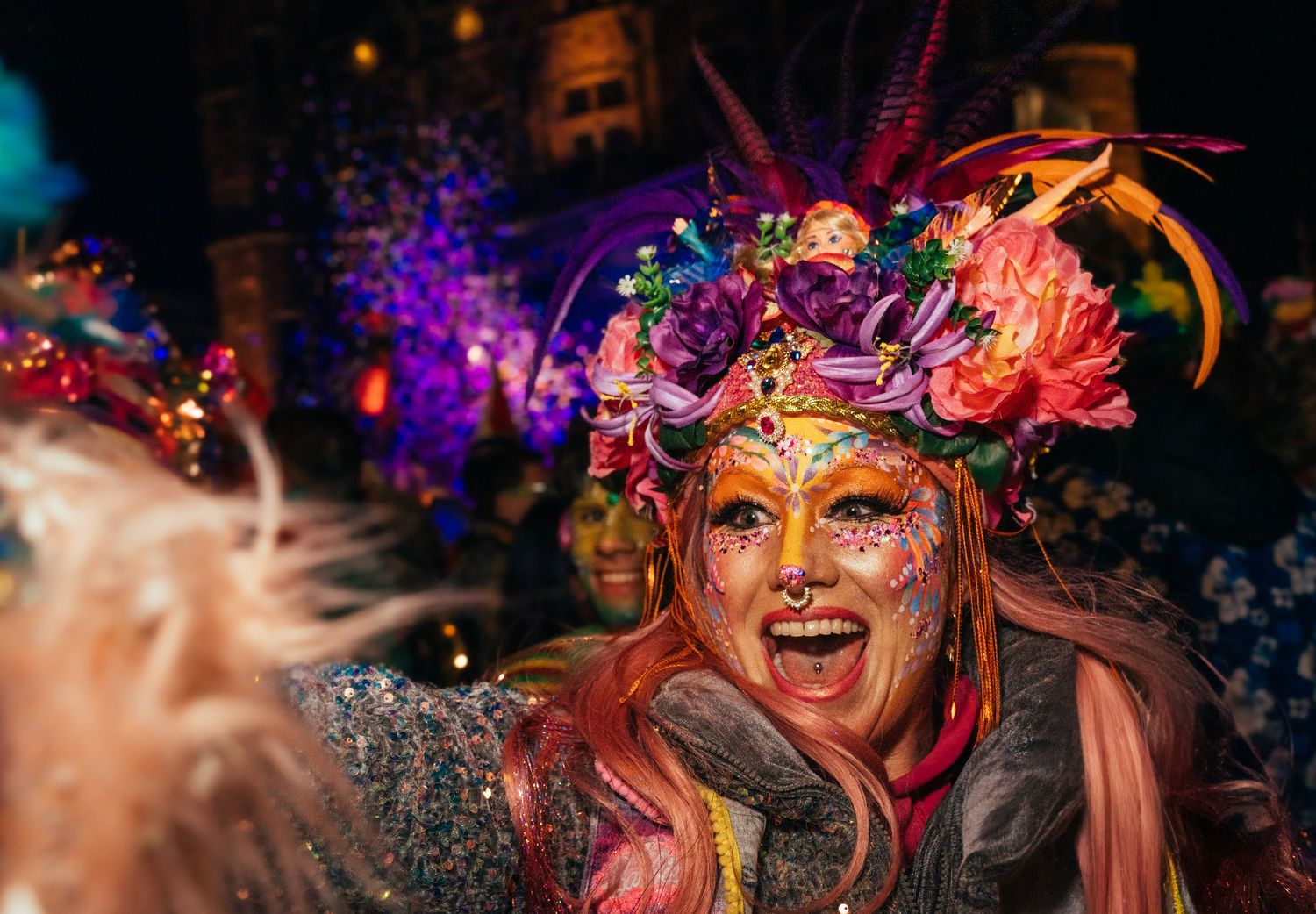 Close-up portrait showcasing an elaborate, colorful feathered headdress worn by a person at a carnival. Vastelaovend in Venlo Vivitu