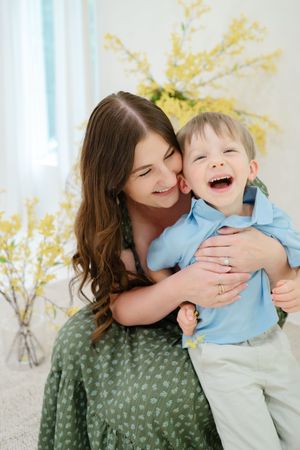 A joyful moment of embracing for family photography against a backdrop of yellow spring flowers in Ren Space Studio Edmond, OK