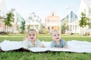 twin boys sit in front of houses in the wheeler district in Oklahoma City, ok for okc family photographer