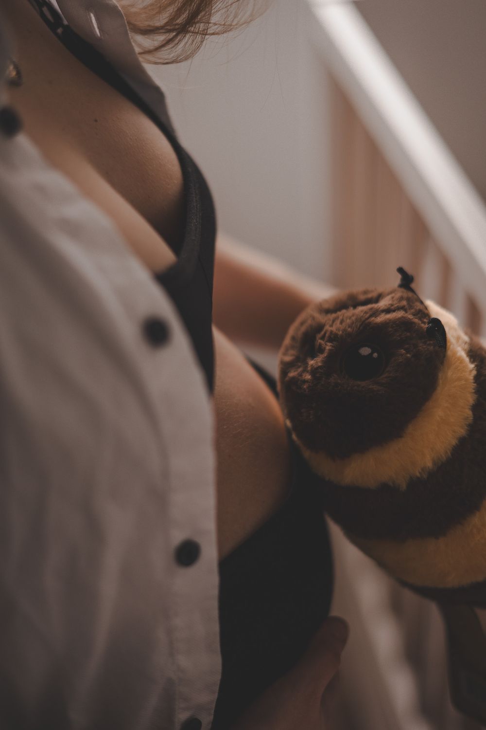 Close-up shot of stuffed plush toy being held in white shirt.
