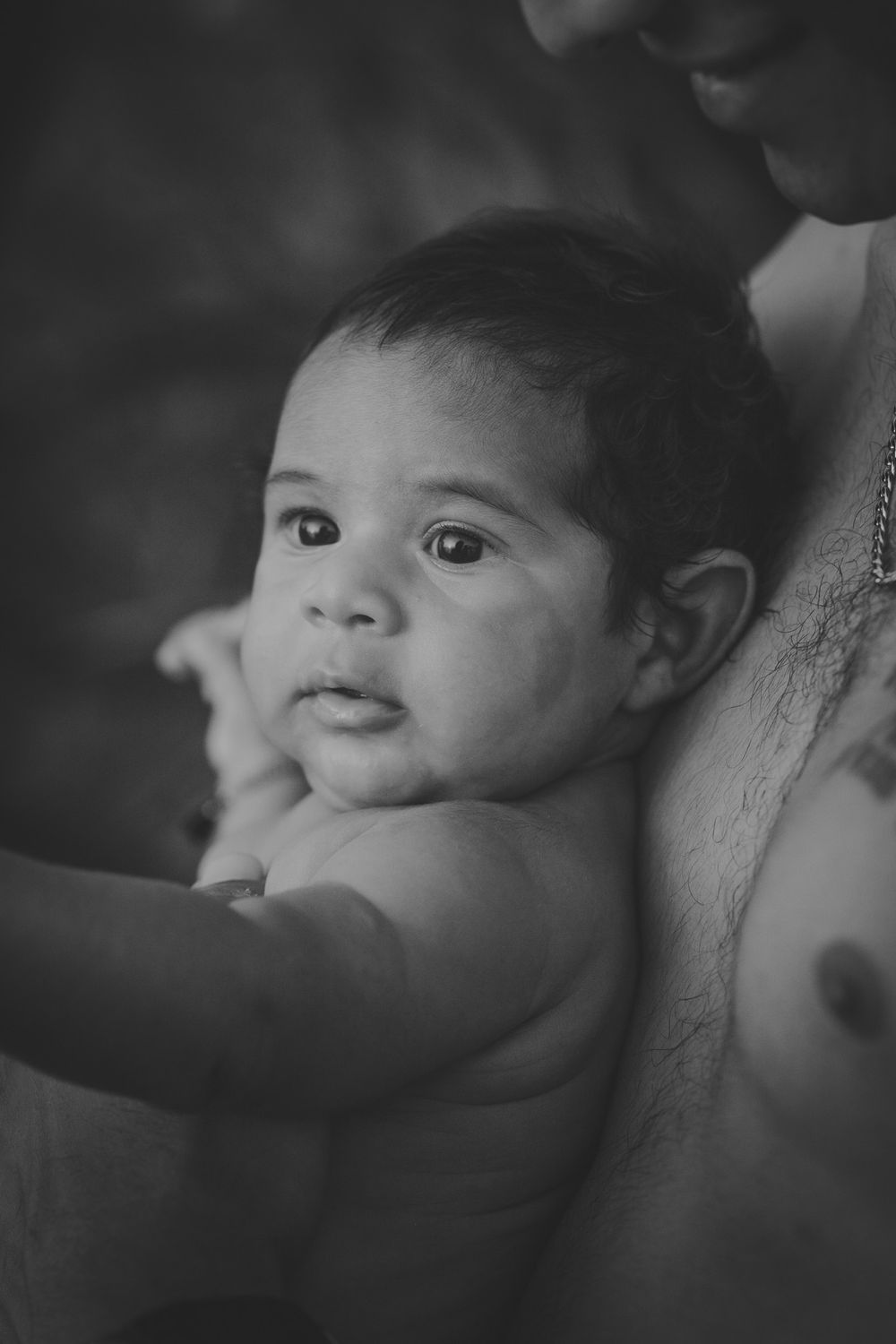 Black and white portrait of baby looking to side with gentle expression.
