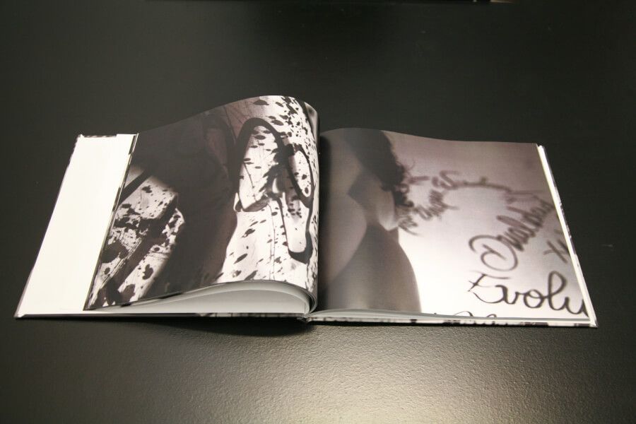 Open photography book displaying high contrast black and white artistic images.