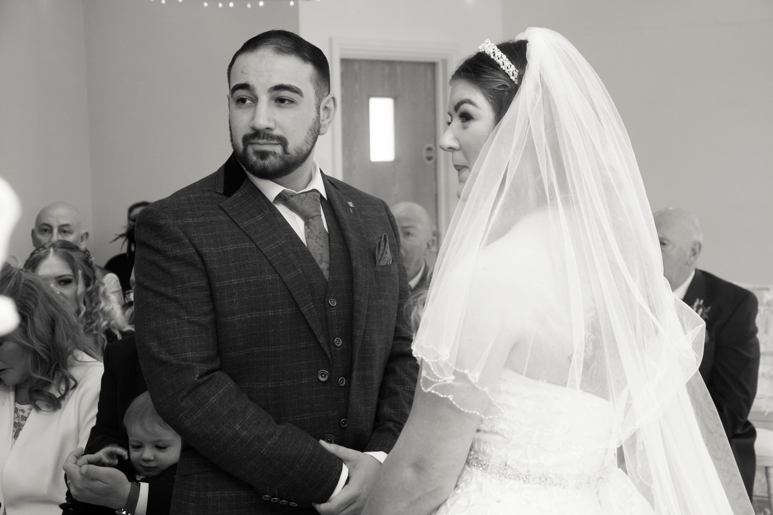 A black and white ceremony photo capturing a solemn wedding moment.