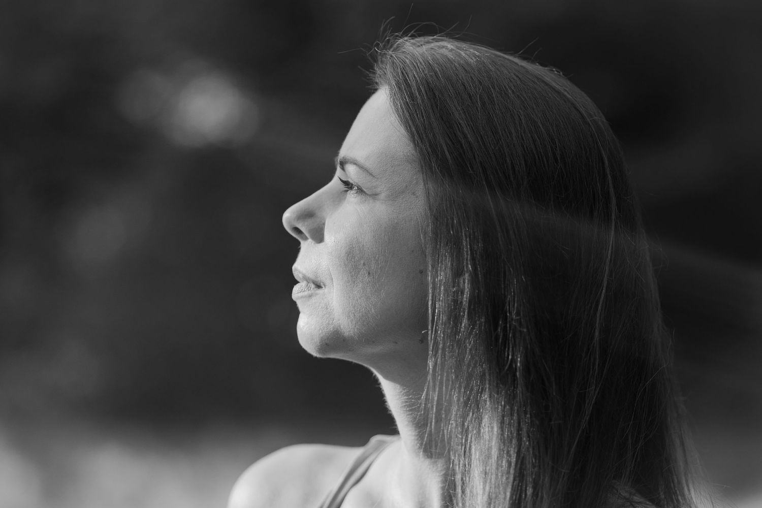 Black and white portrait series showing a contemplative side profile against dark background.