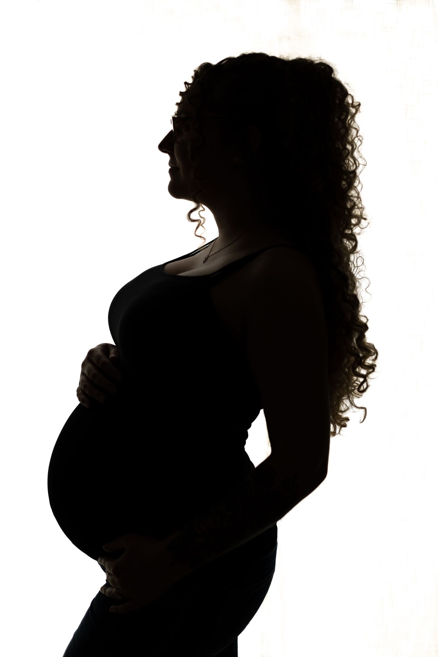 The silhouette of a pregnant, curly-haired goddess.