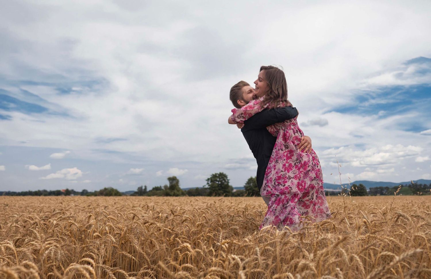 Couple embracing in wheat field under cloudy sky. in Melbourne photography nature