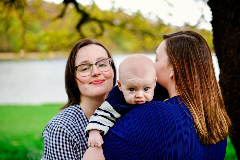 Intimate family moment captured outdoors in garden setting.