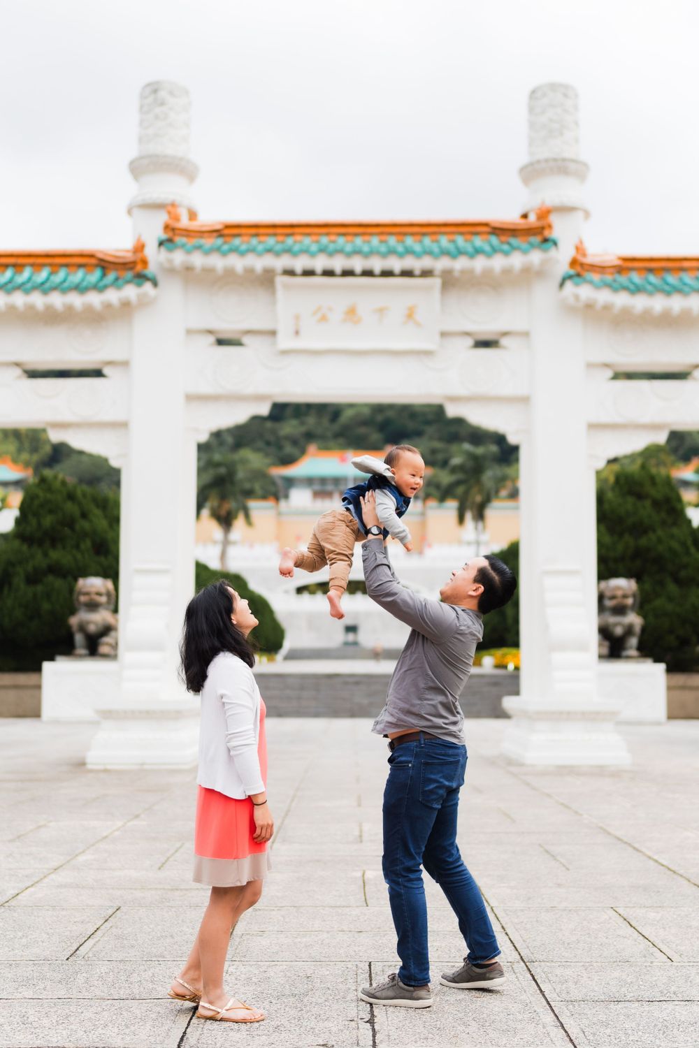 dad throwing baby up while mom watching at the National Palace Museum