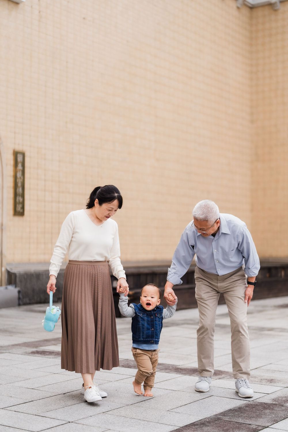 grandparents holding a kid in front of National Palace Museum