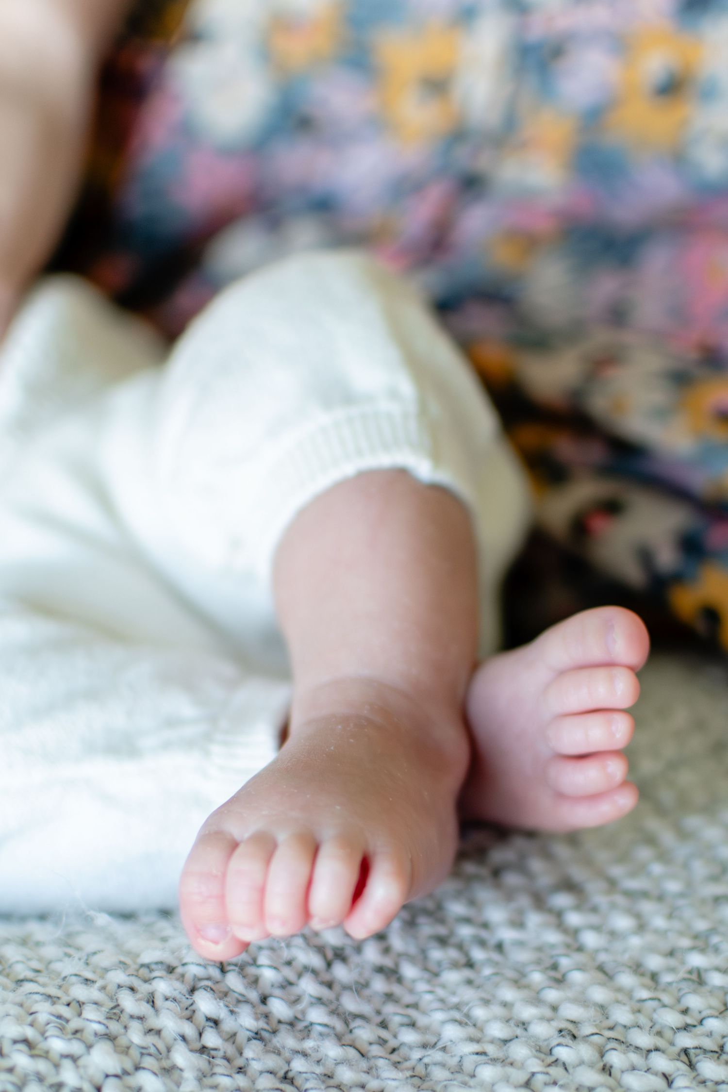 Baby's toes as she snuggles close to Mom on the bed.