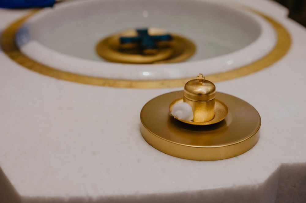 Wedding rings displayed on a gold decorative plate with white and gold accents.