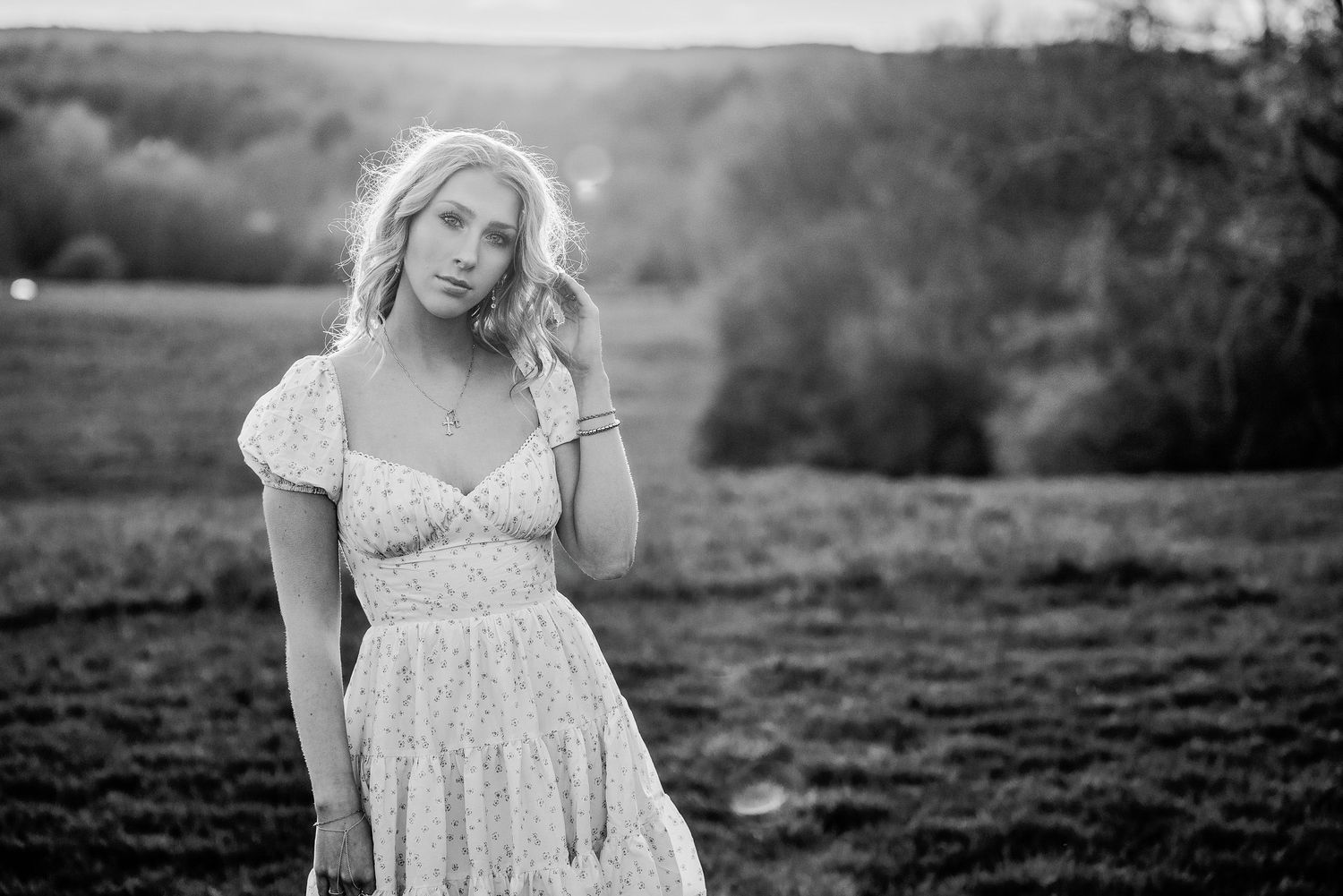 A black and white photo of a senior girl in a field in Berlin Ma