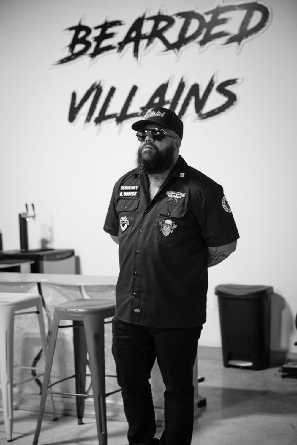 Black and white interior shot with text 'BEARDED VILLAINS' visible on wall.