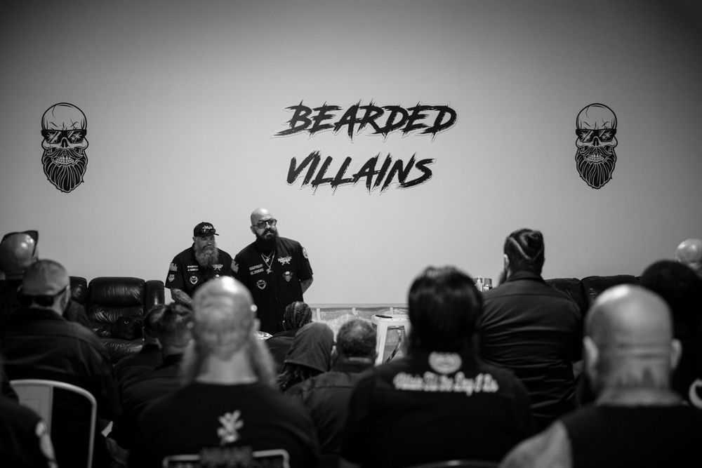 Black and white image of an audience facing a presentation with skull decorations and text.