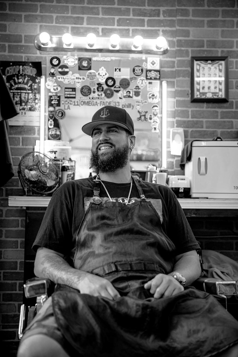 Interior shot of barbershop with vintage mirror and decorative stickers on brick wall.