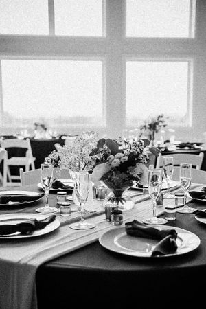 Elegant wedding reception table setting with floral centerpiece and formal place settings.