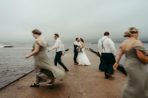 Wedding party running and dancing on beach in motion blur effect.