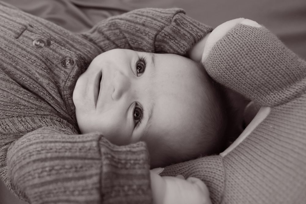 black and white baby with dino toy