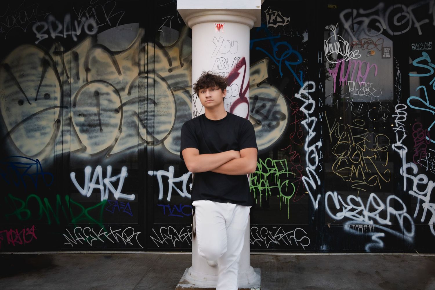 Urban senior portraits for him in downtown Las Vegas: bold graffiti backdrops and street-style vibes for a modern edgy look.
