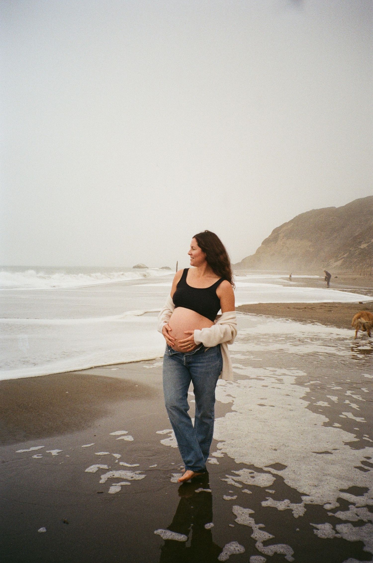 outdoor maternity photography capturing movement, wind, and natural connection on film