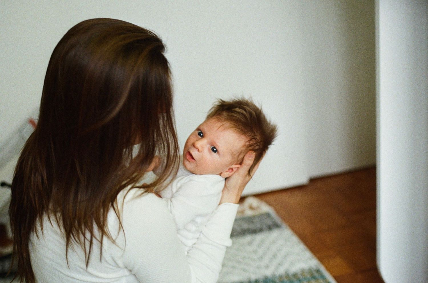 film newborn session in a cozy home setting with gentle light and unposed, intimate moments