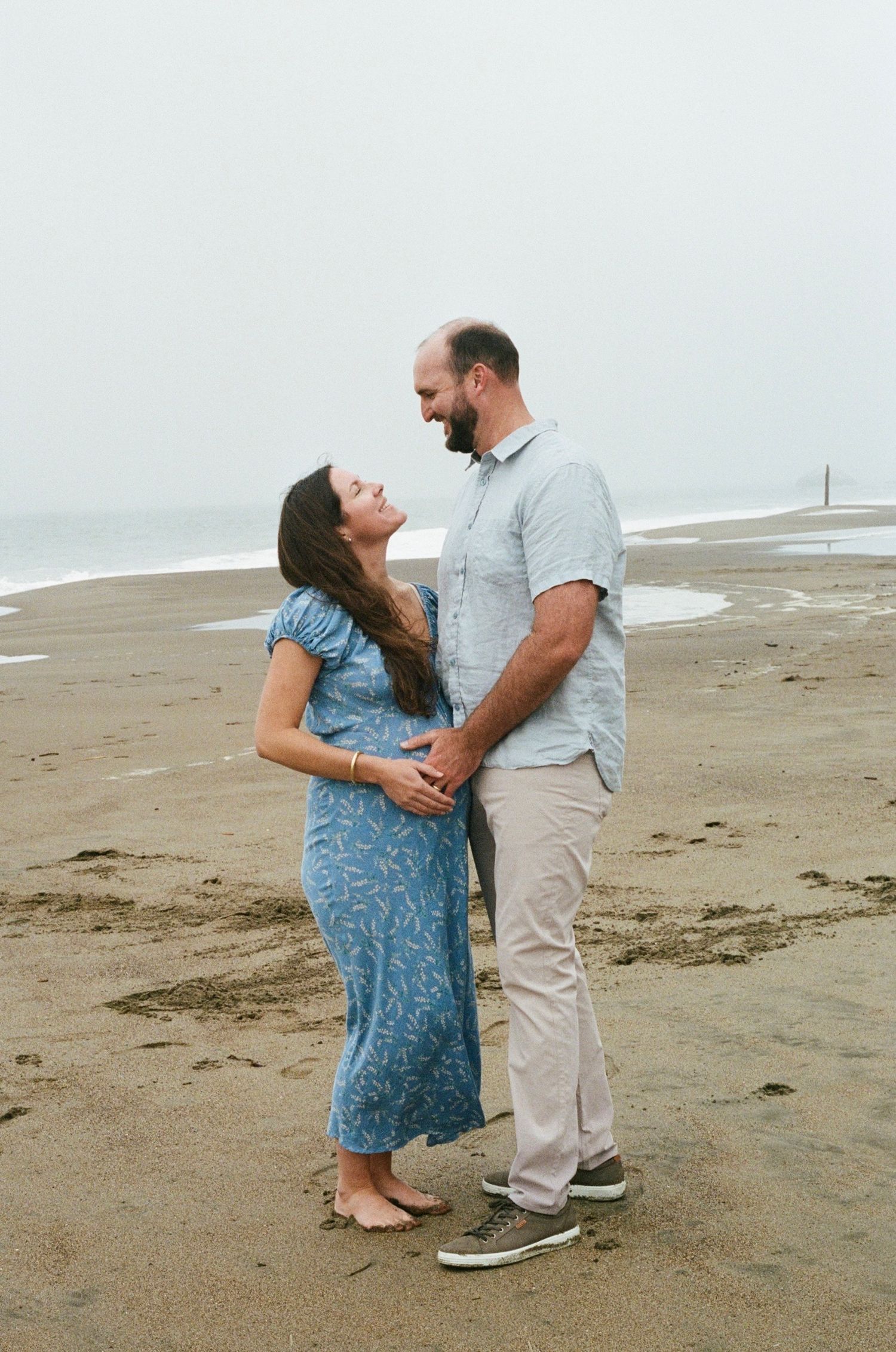 outdoor maternity photography capturing movement, wind, and natural connection on film