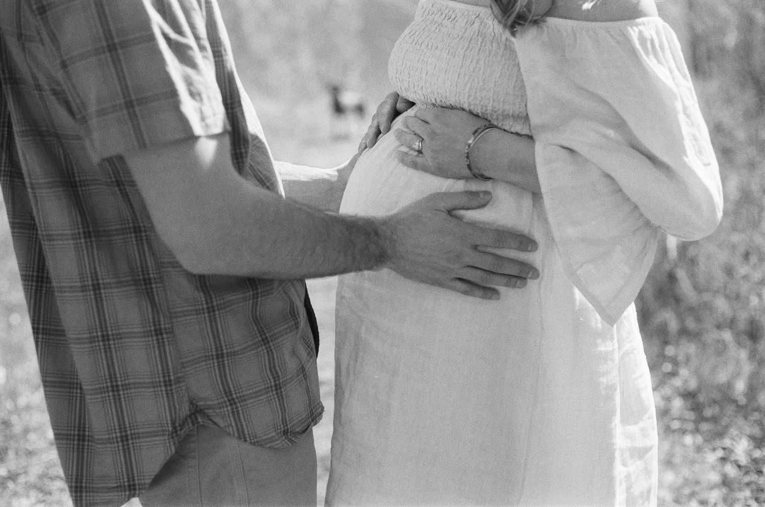 outdoor maternity photography capturing movement, wind, and natural connection on film