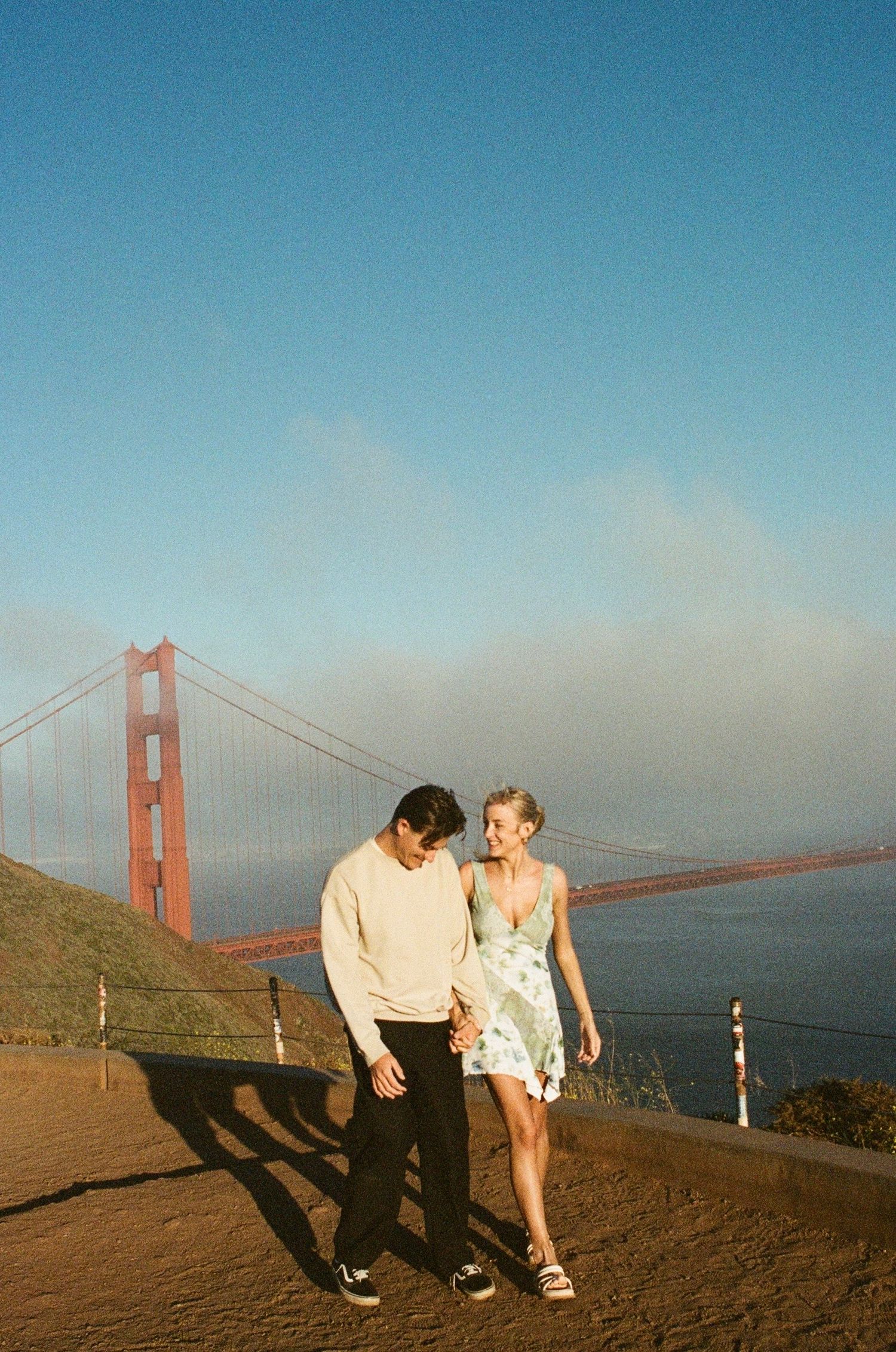 Documentary style engagement photography in San Francisco featuring a couple laughing together outdoors on film