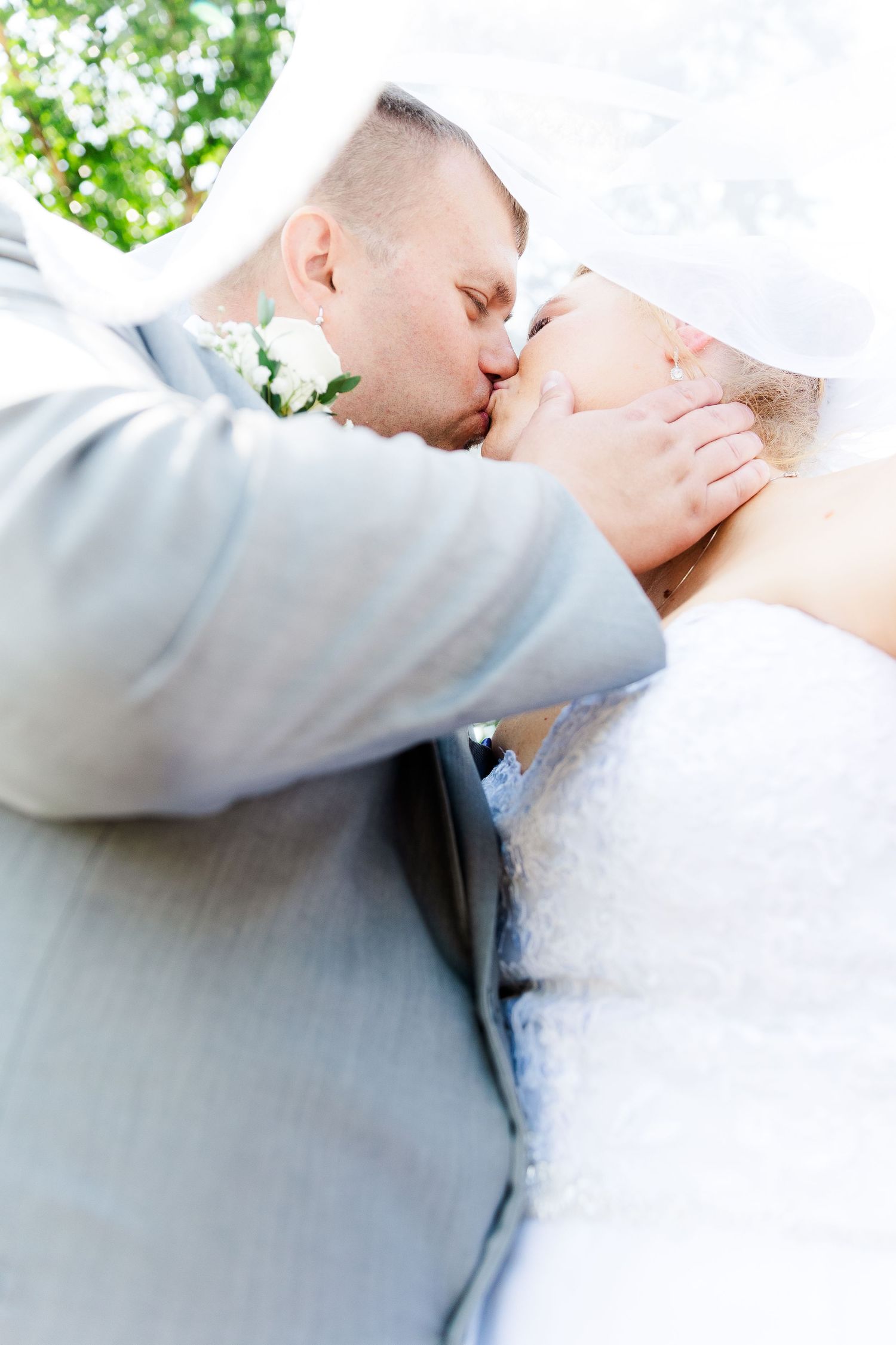 An intimate wedding kiss captured from a creative upward angle.