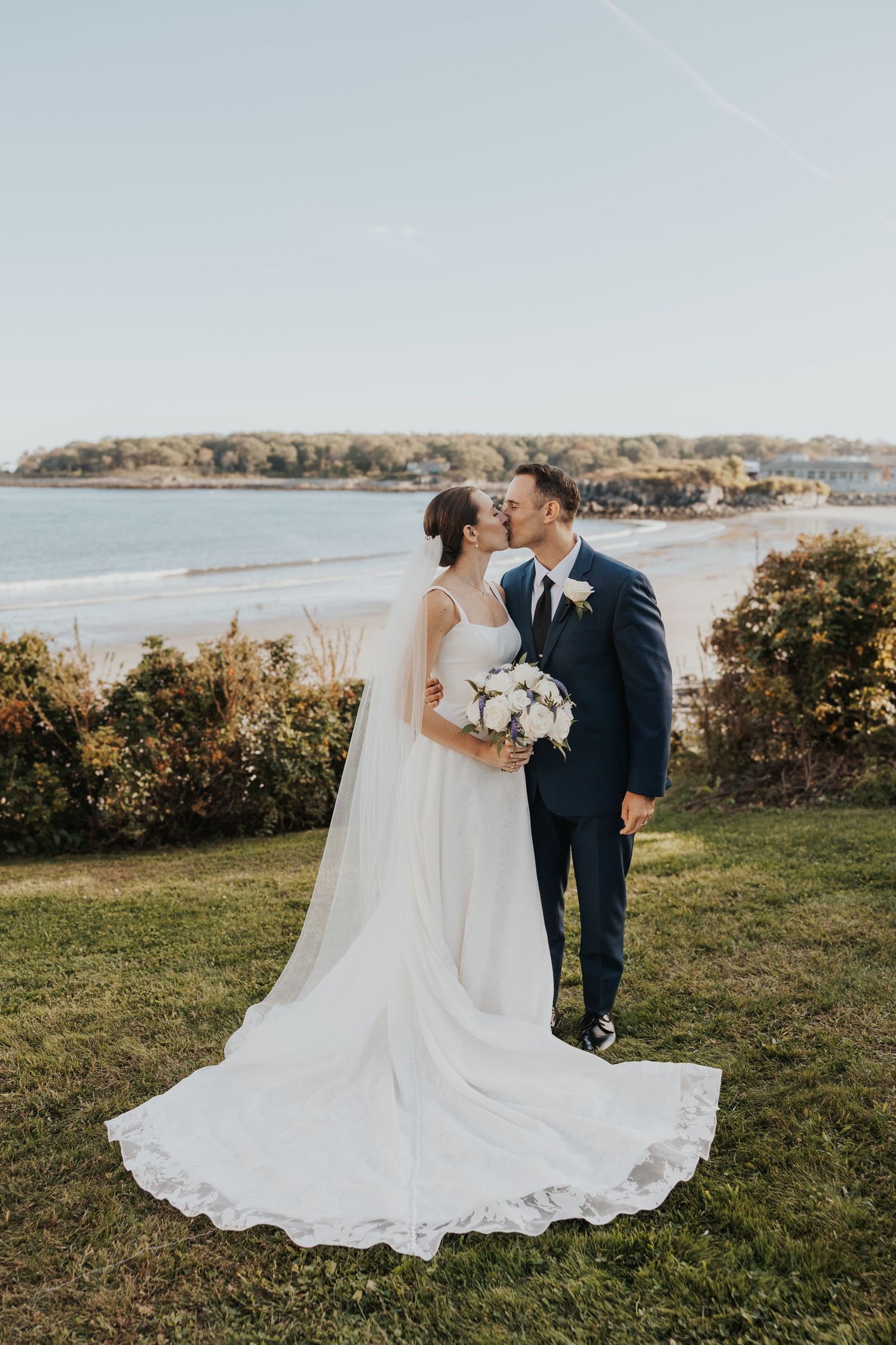 An intimate wedding portrait capturing a tender moment between newlyweds outdoors.