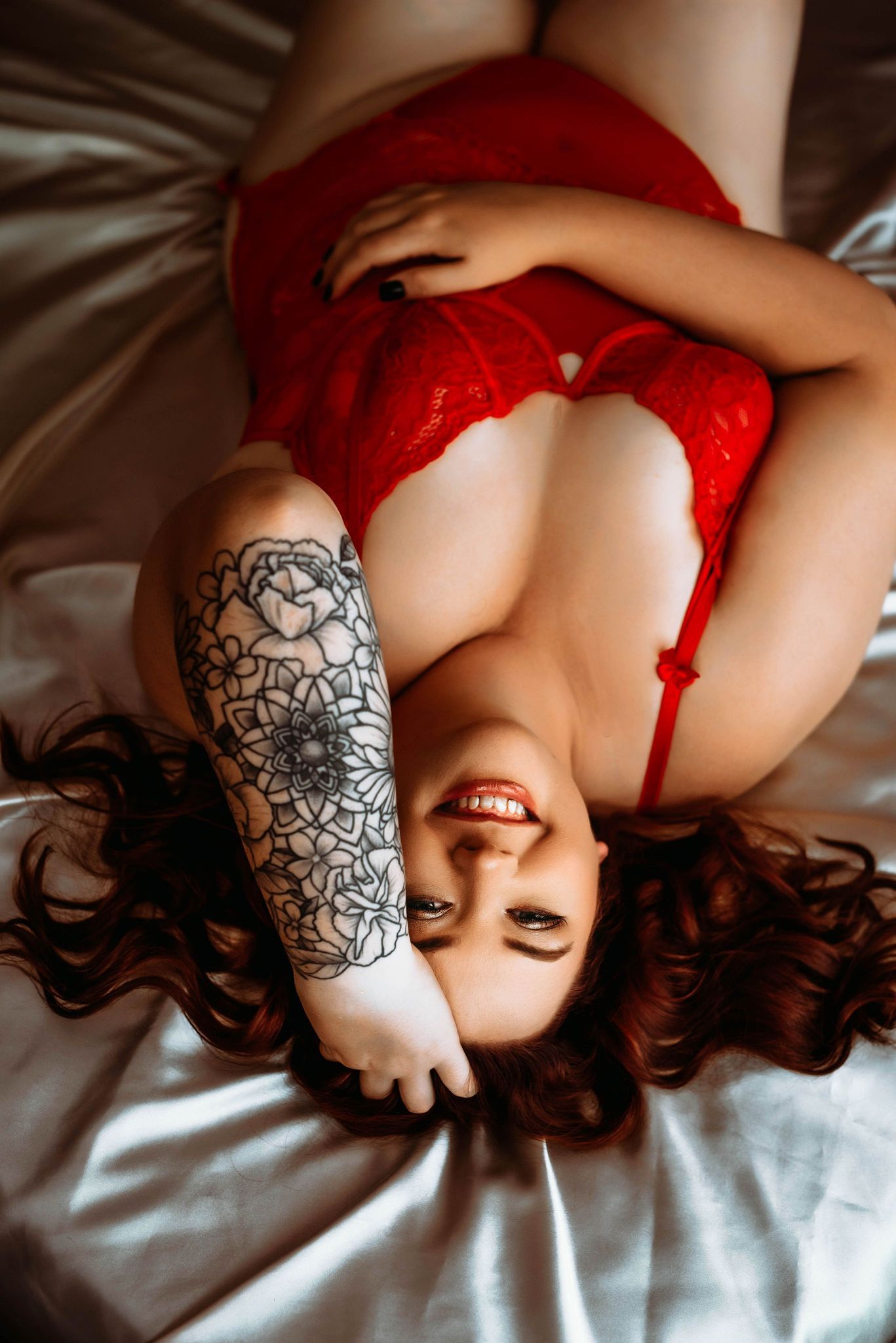 Red haired woman smiles during her boudoir session in downtown Cape Girardeau
