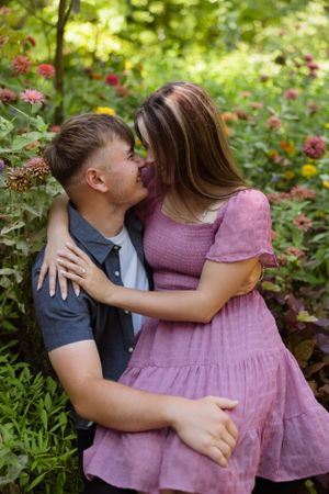 Intimate embrace among blooming pink flowers in lush summer garden.