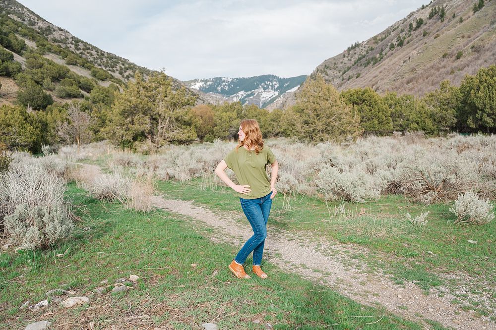 A joyful moment captured in a scenic mountain valley with brush and greenery.
