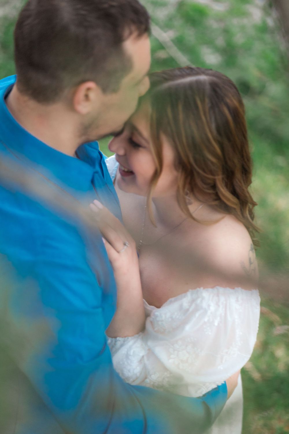 Dreamy candid moment between couple during outdoor engagement session.