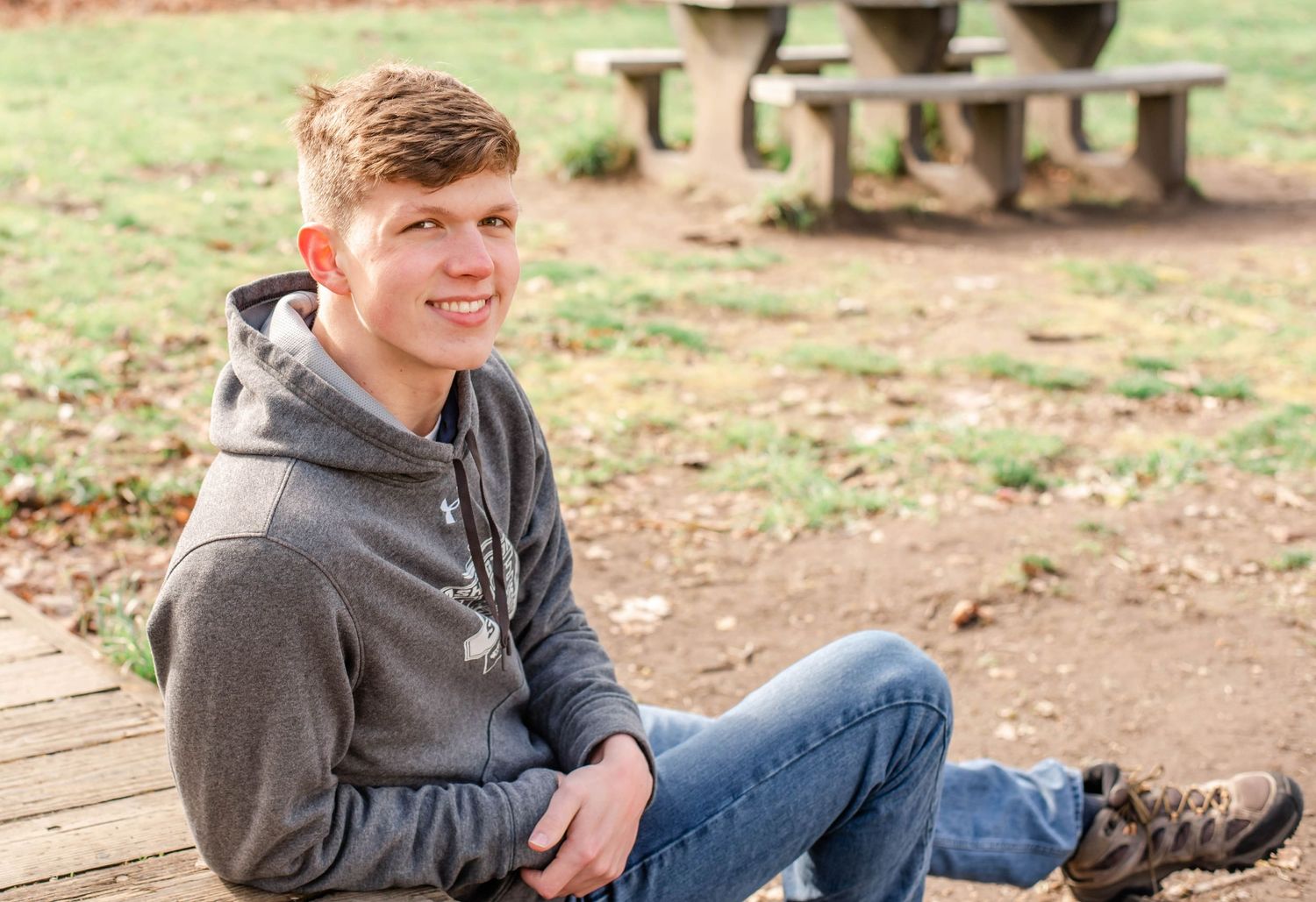 Relaxed outdoor photography session on wooden benches in a park setting.