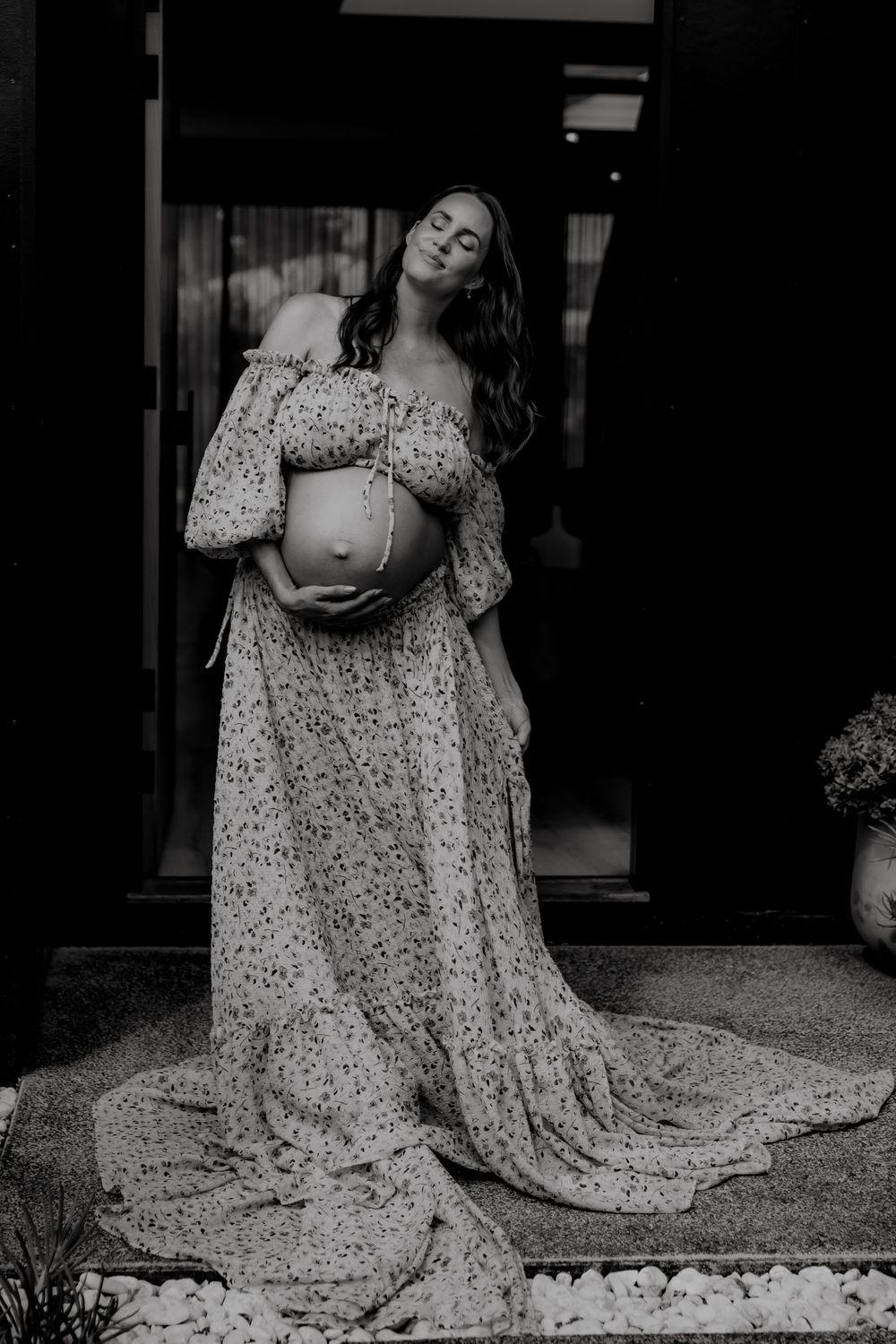 Artistic black and white portrait of person in flowing patterned dress.