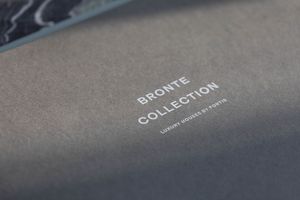 Close-up of a gray Bronte Collection luxury houses by Fortis brochure cover with silver embossed text.