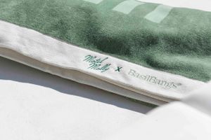 Green and white 'Motel Molly' branded towel or textile product showing Basil Bangs collaboration details.