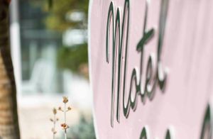 Elegant cursive text in dark green against a soft pink background.