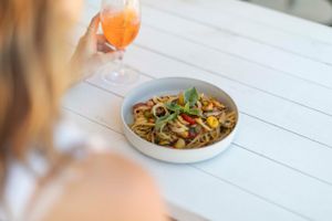 Bowl of seafood pasta served on white table.