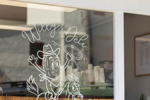 Black and white text displays on a reflective glass window surface with a blurred background.