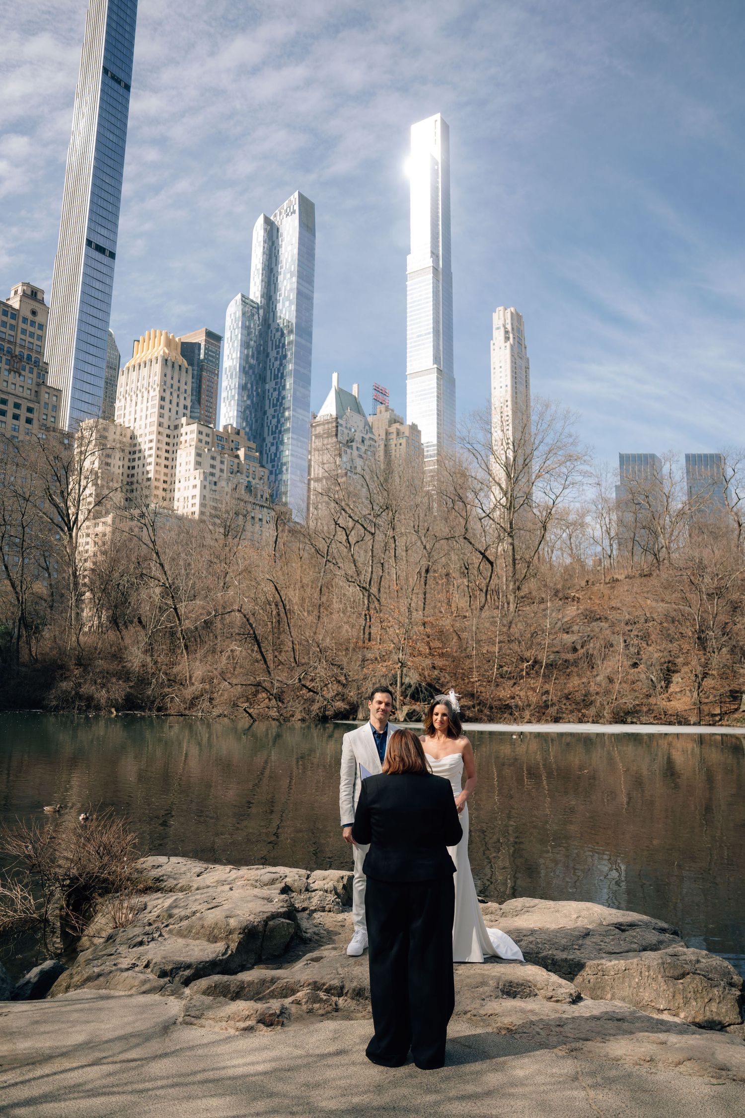 Panoramic sequence showing a couple looking at the New York City skyline from Central Park's lake on a sunny day.