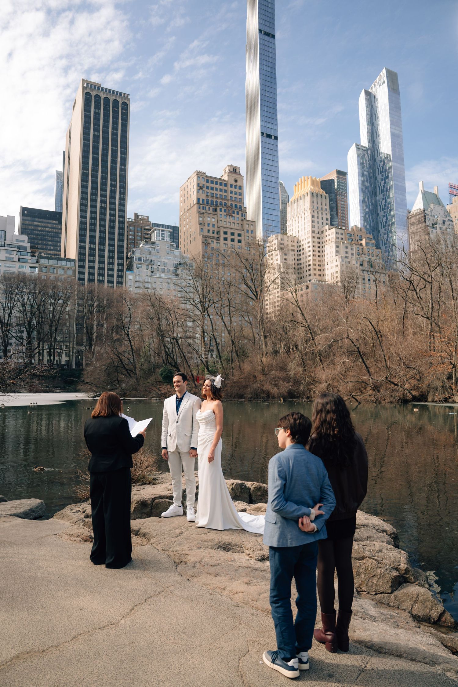Sequence of photos showing a wedding photoshoot against New York City skyline and Central Park lake on a winter day.