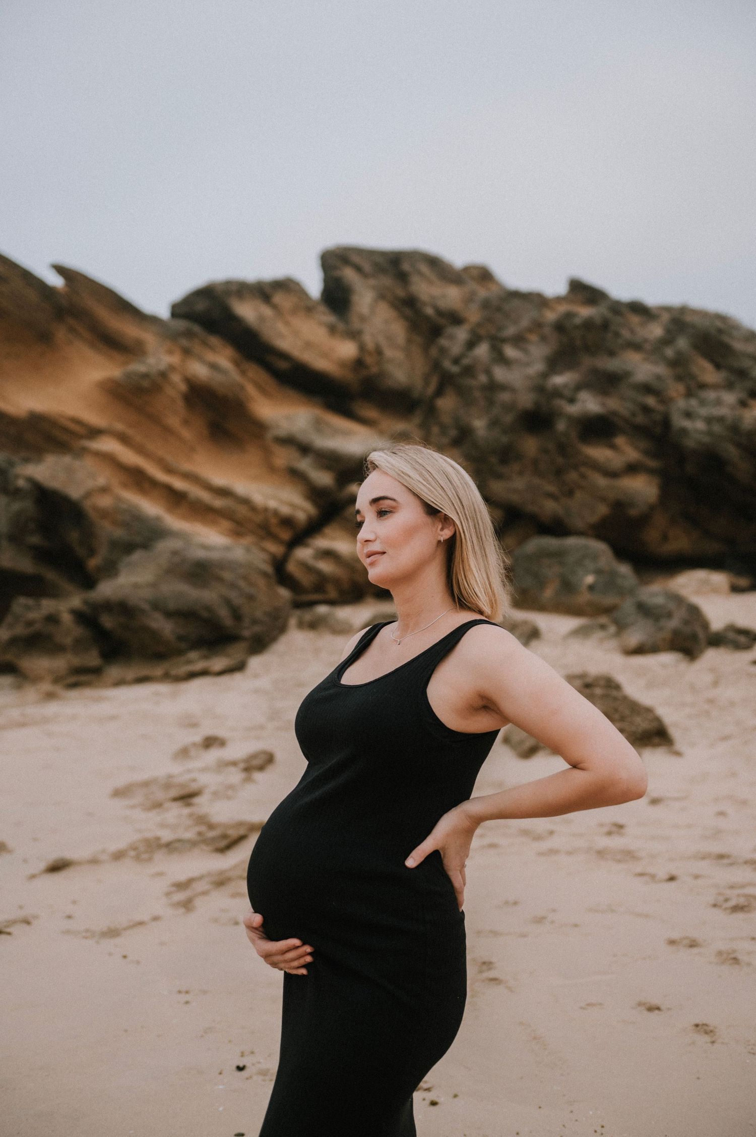 Maternity photo of a beautiful mother-to-be wearing a black dress in Stilbaai, capturing an elegant and peaceful pregnancy portrait