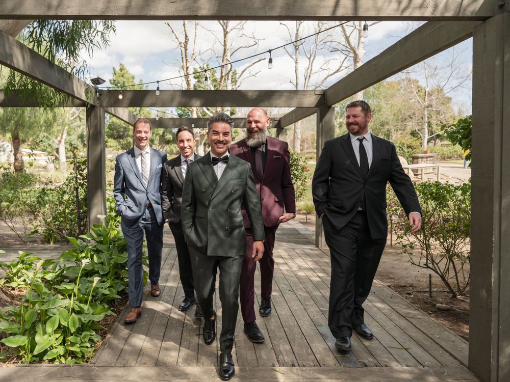 Group walking together on wooden deck during formal event.