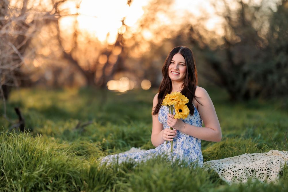 Tucson, AZ senior girl in the desert at golden hour in grass with a bouquet of flowers