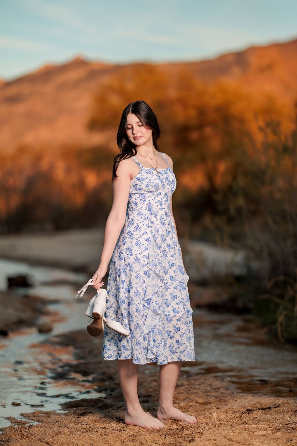 Tucson, AZ senior girl in the desert at golden hour with mountains and water in the was